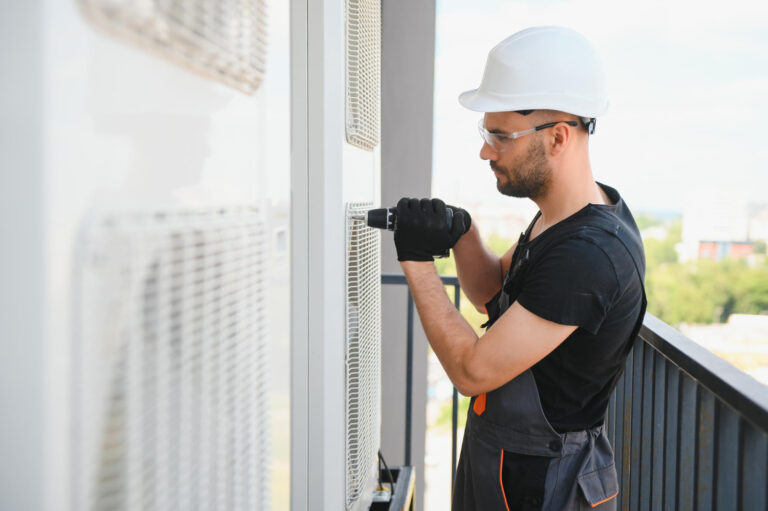 Technik AM KLIMA kontroluje jednostkę zewnętrzną klimatyzacji podczas uruchomienia systemu